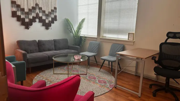 Interior common space with colorful seating arrangements, coffee table, and wall artwork