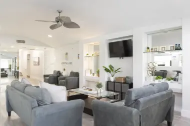 Interior common area with seating, wall-mounted television, shelving, and modern furnishings