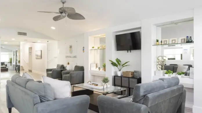 Interior common area with seating, wall-mounted television, shelving, and modern furnishings