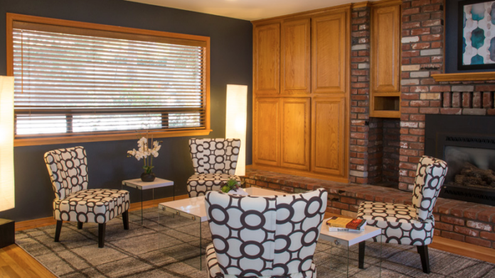 Interior common area with geometric patterned chairs, fireplace, dark accent wall, and wooden cabinetry
