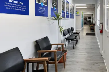 Interior hallway displaying blue motivational signs with facility core values and wooden seating areas