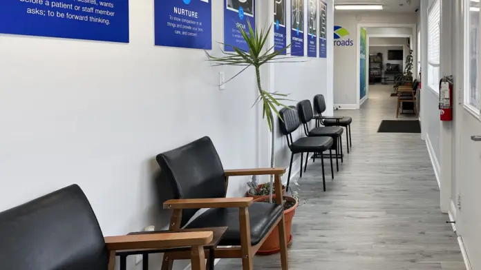 Interior hallway displaying blue motivational signs with facility core values and wooden seating areas