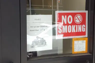 Exterior entry door with no-smoking sign, P.A.R.C facility closure notice, and informational postings on glass