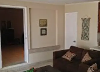 Interior hallway with white walls, open doorway, black furniture, and access to common areas