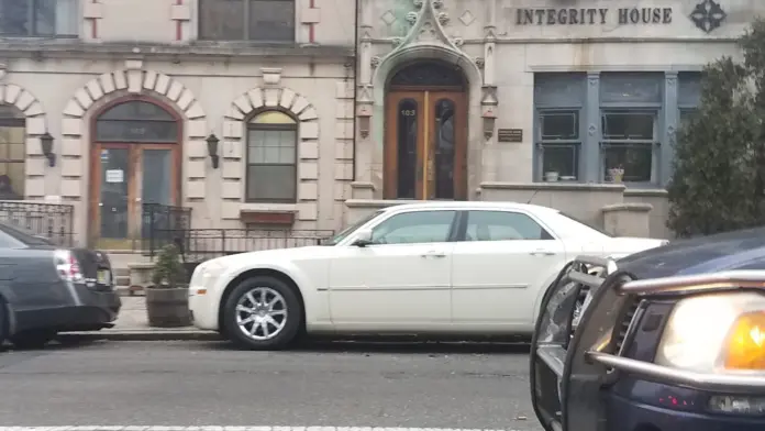 Front facade of Integrity House with ornate stone detailing, arched entry, and street-level parking