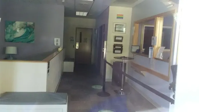 Interior corridor showing reception counter, walls with artwork, doors, and office windows