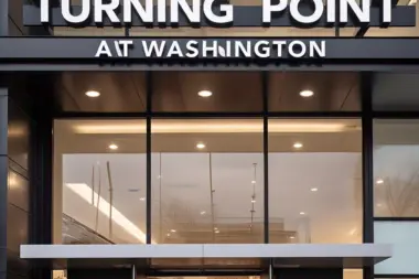 Front exterior showing illuminated Turning Point at Washington signage, glass storefront entry doors, and lit reception area interior visible through windows.