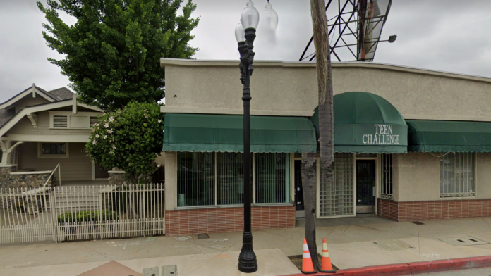 Exterior front facade of Teen Challenge facility showing green awning with facility name, brick and stucco construction, street-level storefront entrance