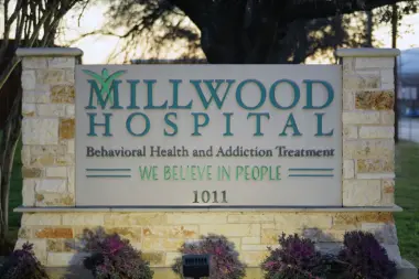 Exterior stone monument sign displaying Millwood Hospital name and behavioral health services with landscaping