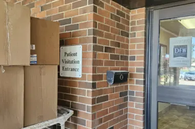 Interior entry vestibule with patient visitation signage, doorway, and service window counter