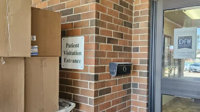 Interior entry vestibule with patient visitation signage, doorway, and service window counter