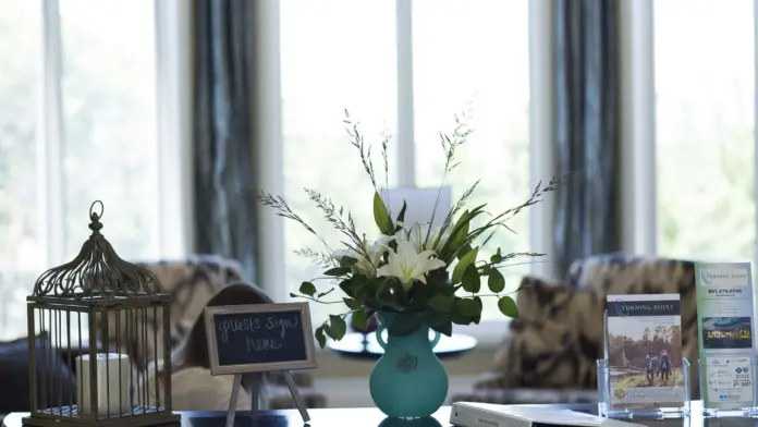 Interior reception desk area showing decorative elements, floral arrangement, and informational materials on display