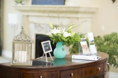 Interior reception area showing wooden desk with decorative floral arrangement, birdcage, and welcome signage