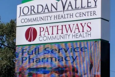 Exterior roadside sign displaying Jordan Valley Community Health Center and Pathways Community Health branding with digital message board