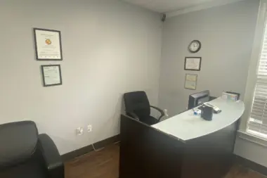 Interior office with desk, computer, office chair, wall-mounted certifications, and window access