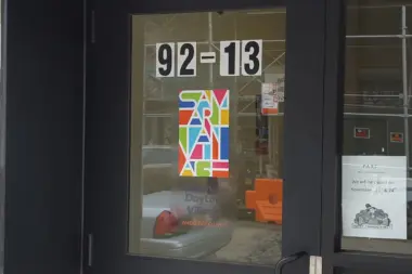 Exterior storefront showing address 92-13, colorful Samaritan Daytop Village logo on window, glass entry door and windows