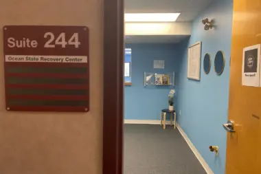 Interior hallway showing Suite 244 sign for Ocean State Recovery Center with blue and yellow accent walls