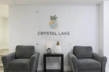 Interior reception space with comfortable gray armchairs, side table, and facility branding