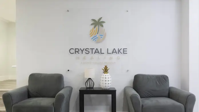 Interior reception space with comfortable gray armchairs, side table, and facility branding